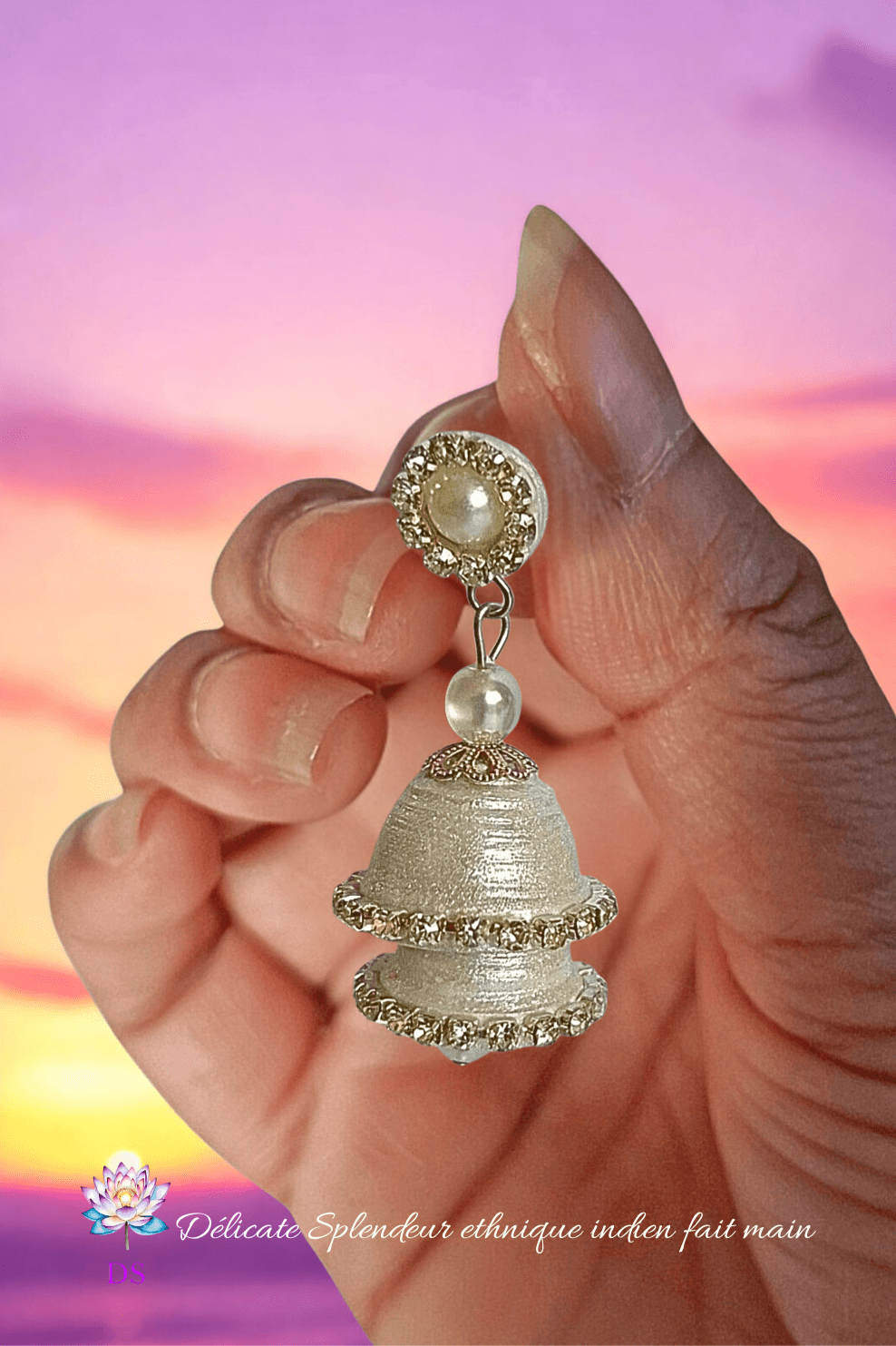 Boucle d'oreille aérienne et délicate, sous un lever de soleil rosée et violet.