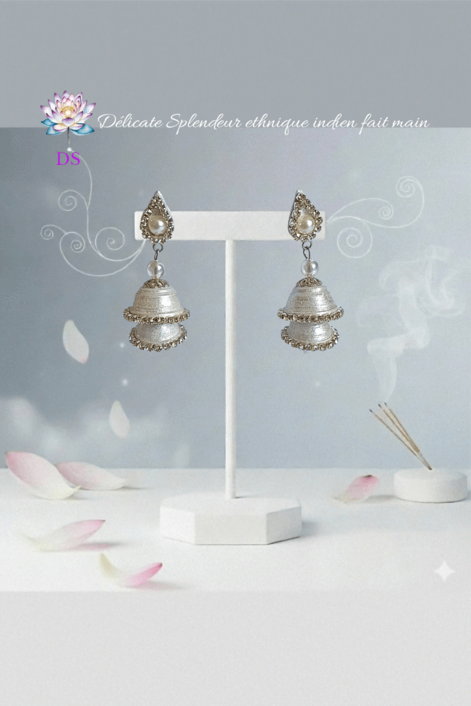 Boucles d'oreilles argentées, Jumkas idéales pour les cérémonies, sur leur présentoir blanc.